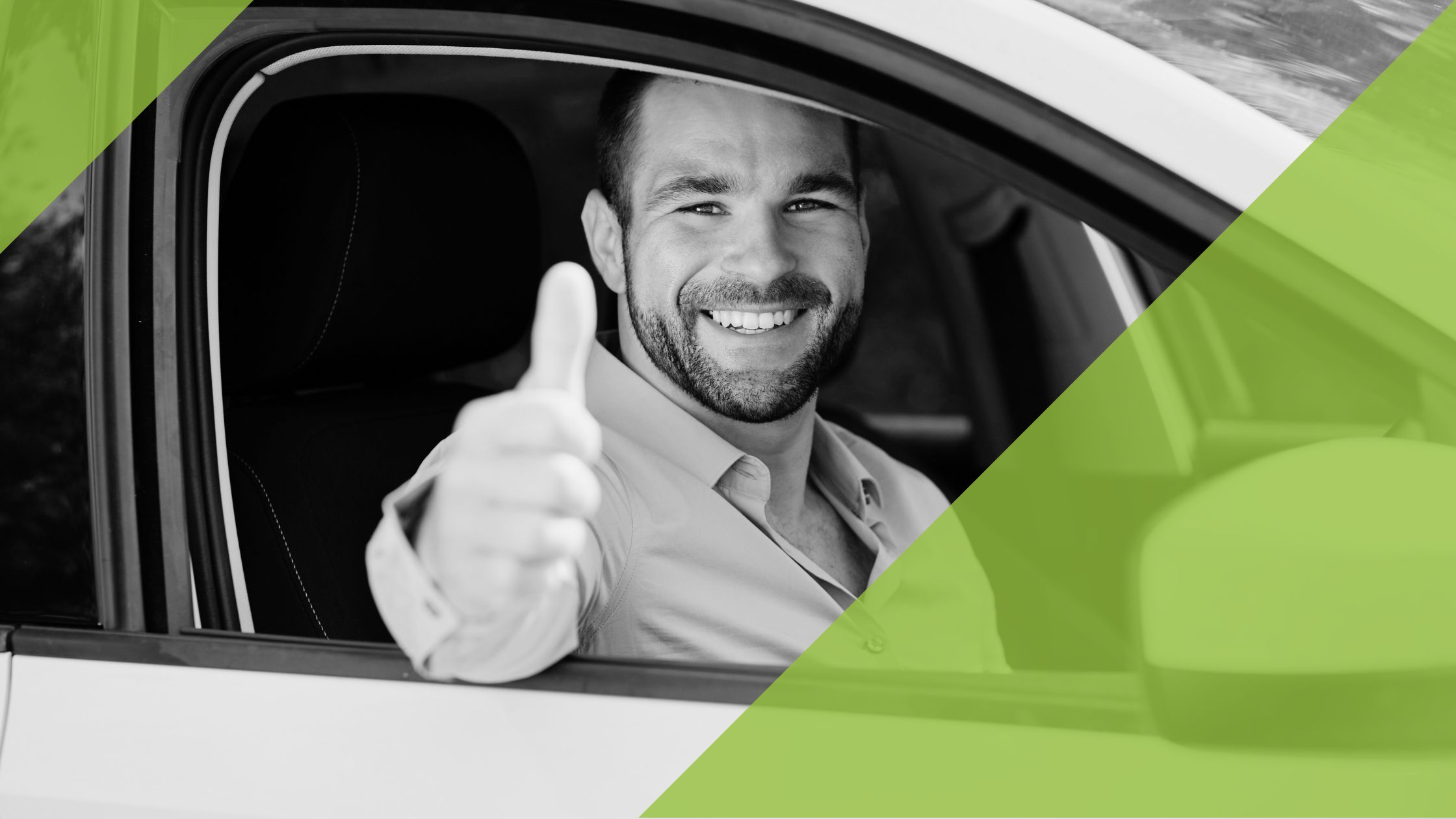 Mann, lächelnd im Auto sitzend und den Daumen nach oben gezeigt.