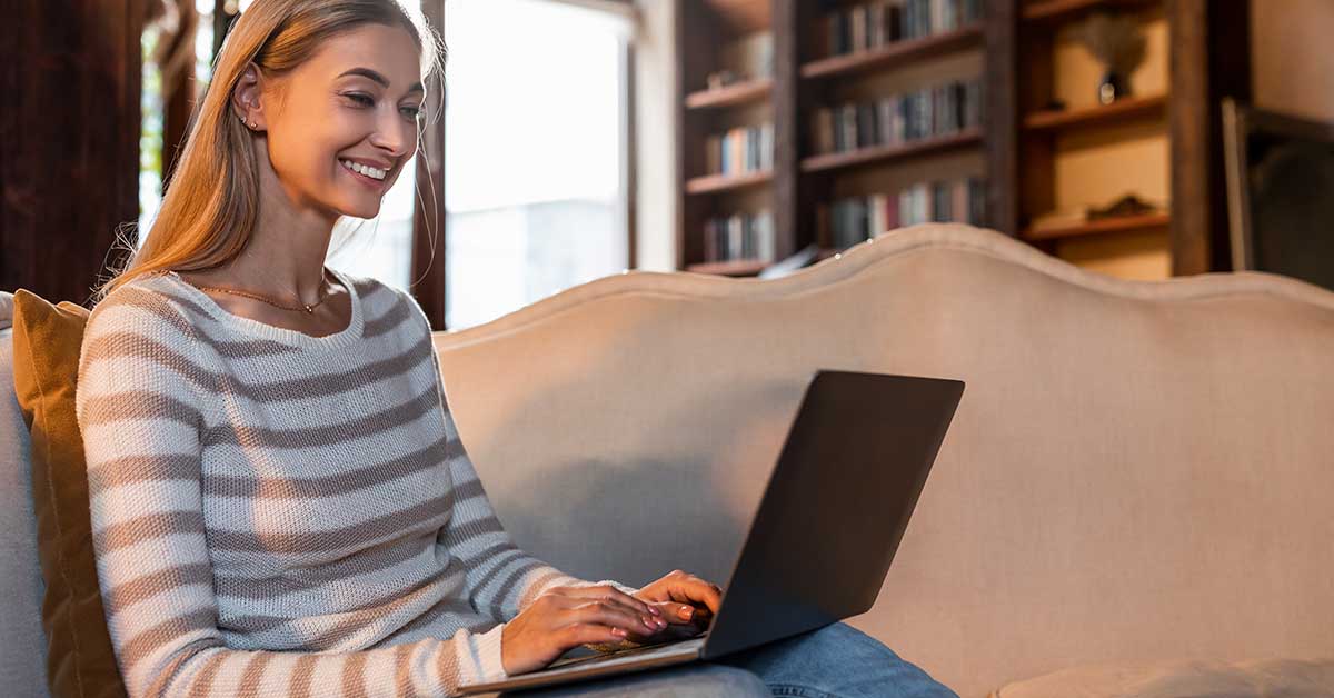 Frau, lächelnd mit Laptop