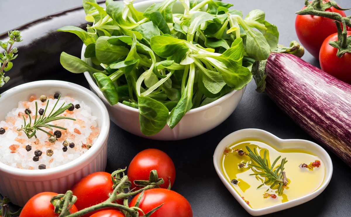 Mix aus rohem Gemüse mit Salz, Gewürzen auf dunklem Hintergrund. Sauberes, gesundes Essen, wenig Salz