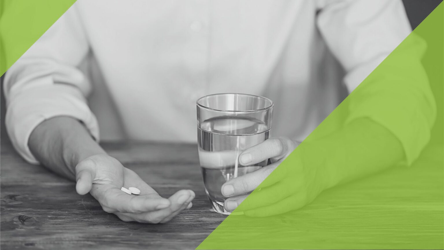 Zwei Hände, in einer Hand eine Tablette und in der anderen ein Glas Wasser