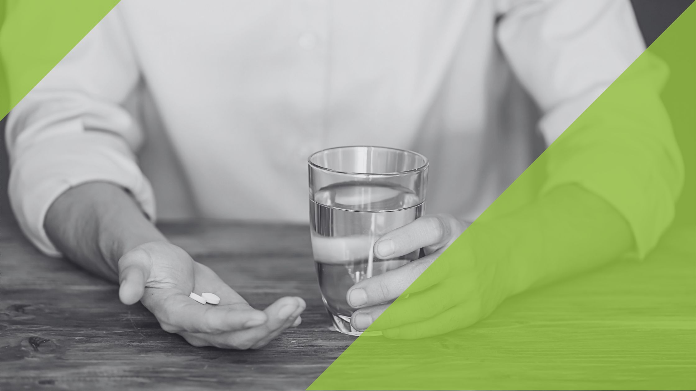 Zwei Hände, in einer Hand eine Tablette und in der anderen ein Glas Wasser