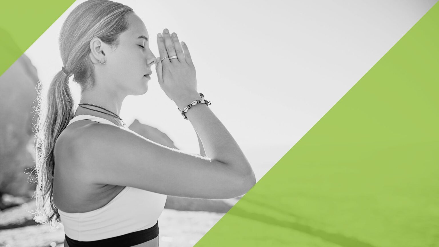 Eine Frau mit geschlossenen Augen macht eine Yoga-Übung am Strand.