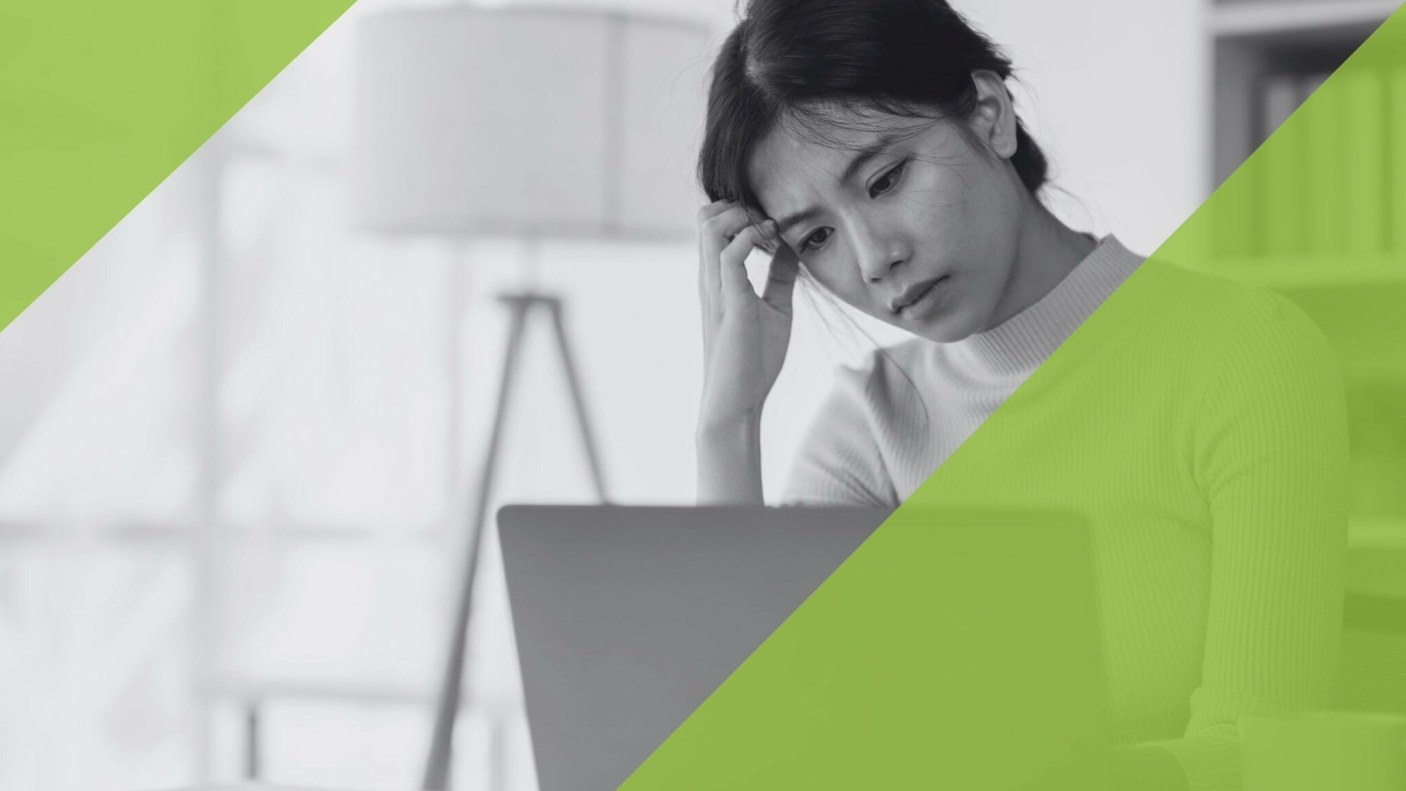 Frau sitzt nachdenklich vor einem Laptop, symbolisiert beruflichen Stress und Depression.