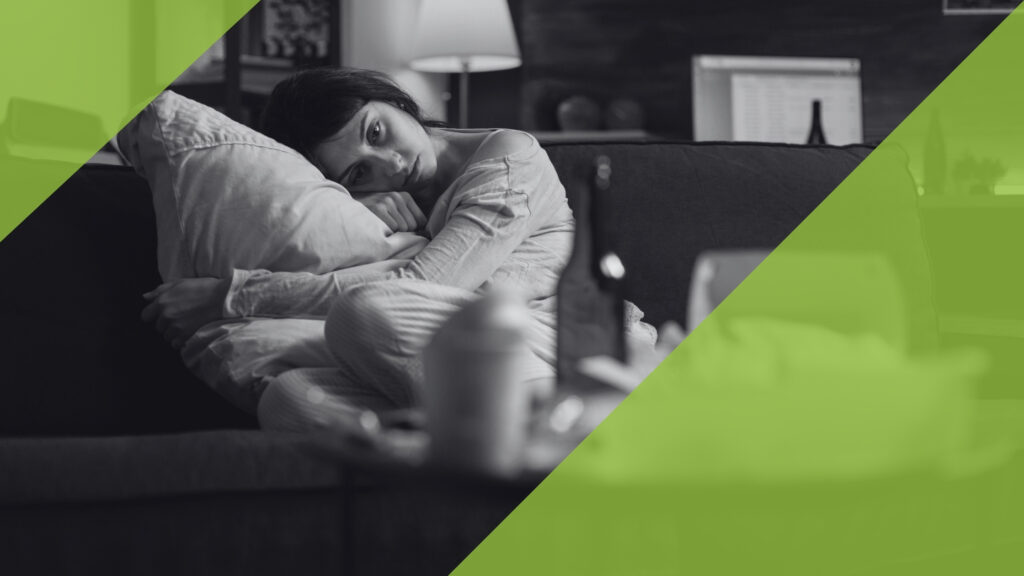 Nachdenkliche Frau mit einem Kissen auf einem Sofa, Symbol für die emotionalen Tiefen der Depression.