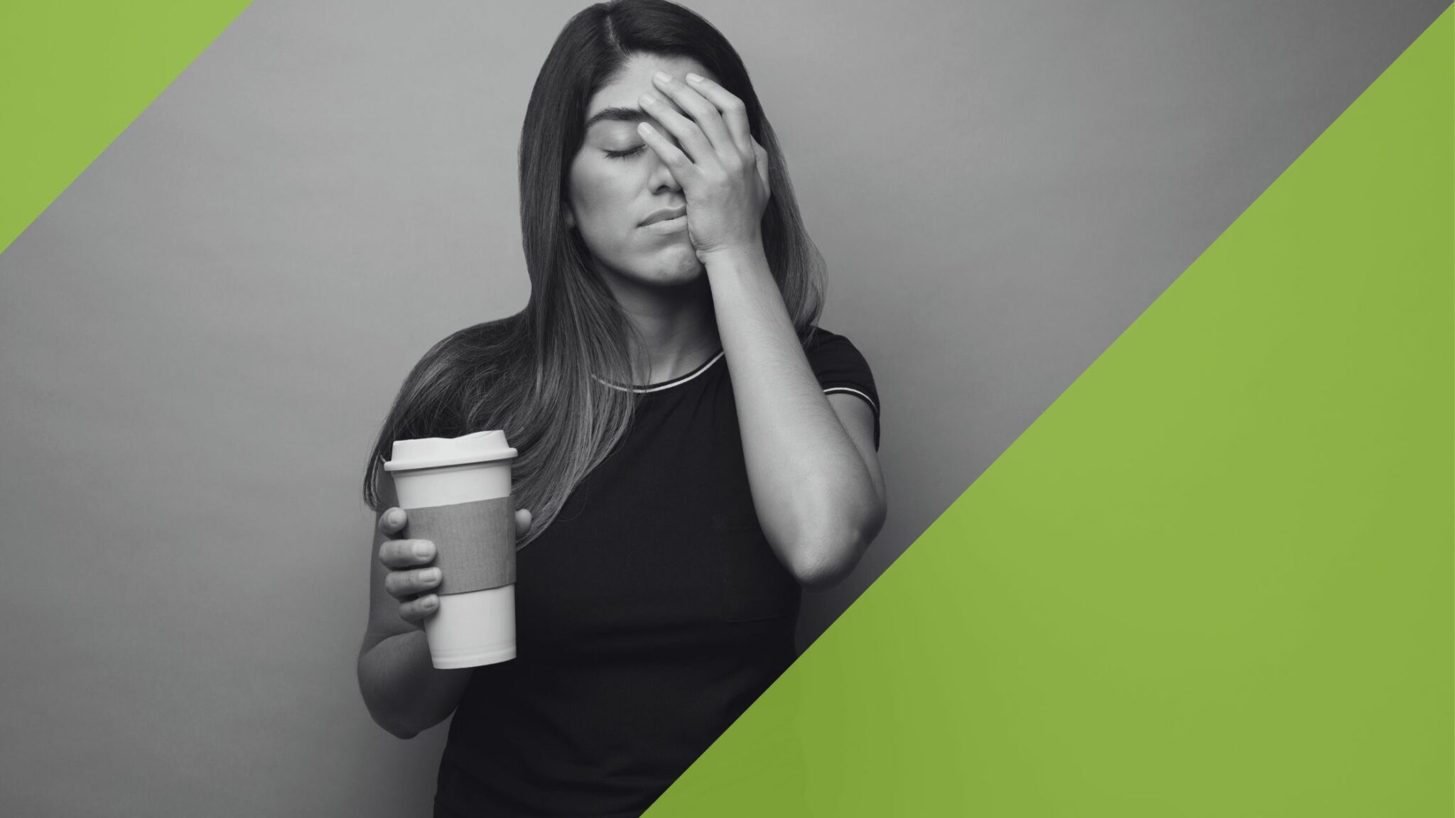 Eine junge Frau mit einem Kaffeebecher in der Hand wirkt erschöpft